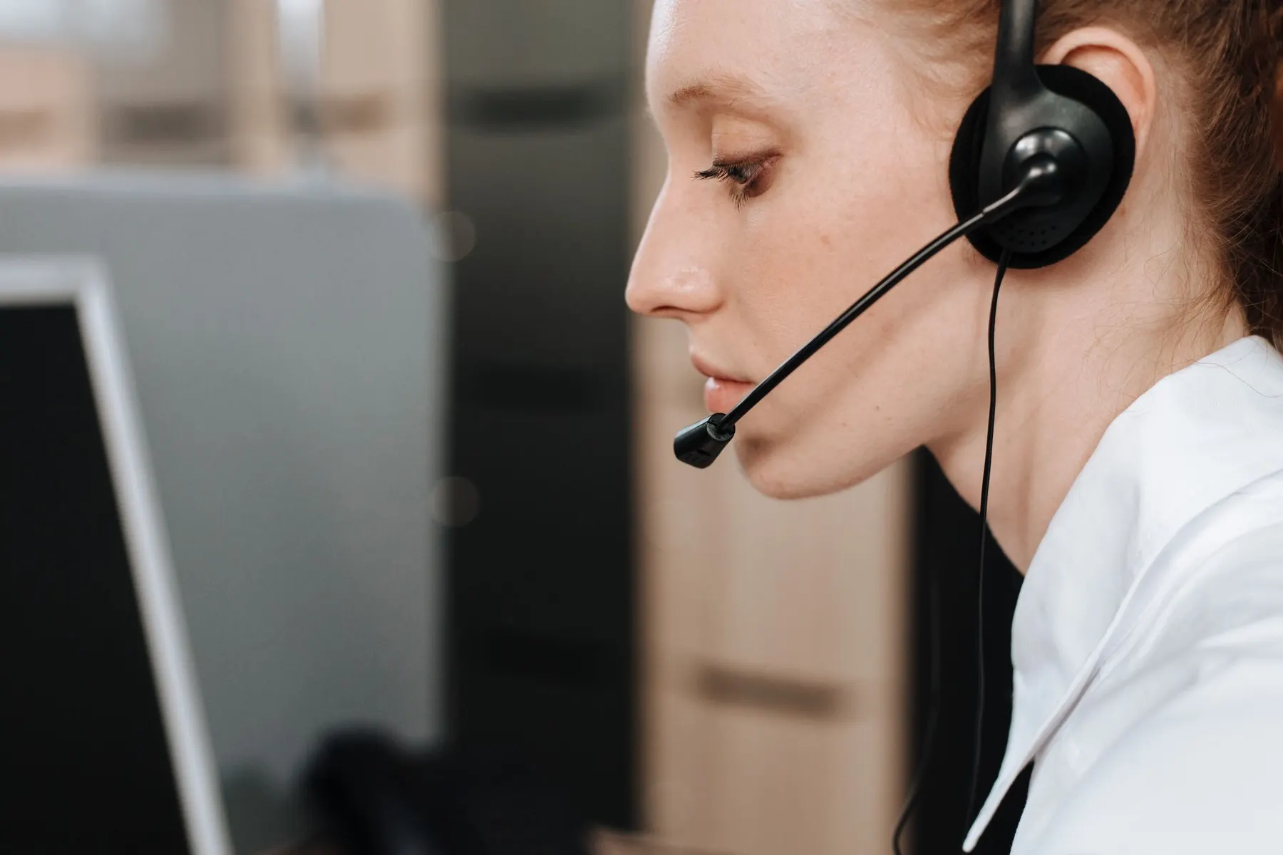 Customer support professional assisting a caller at a workstation