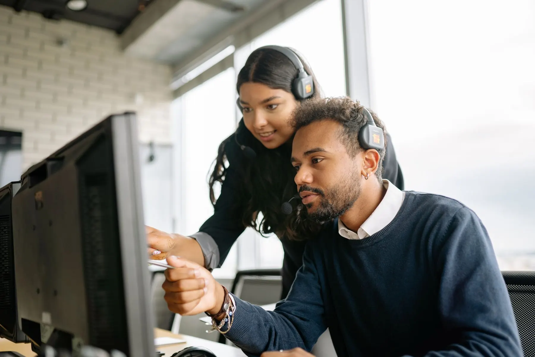 Customer support colleagues working together with headsets